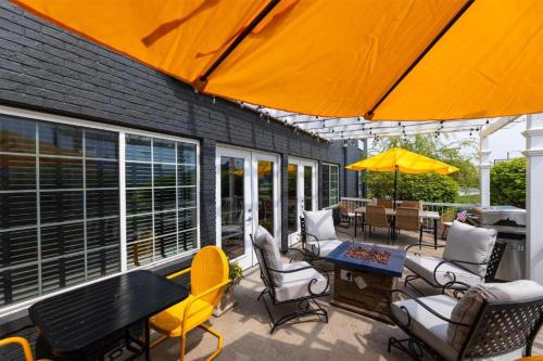 a patio with chairs and tables and an umbrella at Harbor Town Inn, BW Signature Collection in Manitowoc