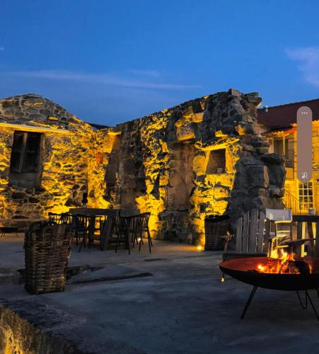 a stone building with tables and chairs at night at Exclusive Pena Rio in Ribeira de Pena
