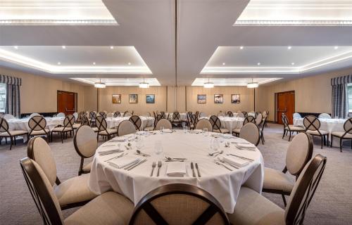 a large room with tables and chairs in it at Thatchers, BW Signature Collection in East Horsley