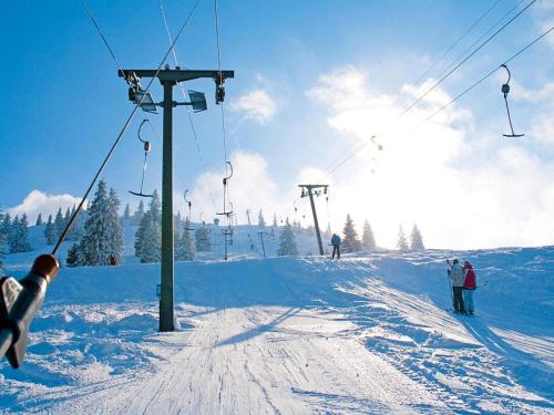 a group of people on a ski lift in the snow at Lush apartment in Bayrischzell with 2 saunas in Bayrischzell