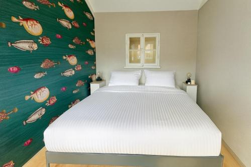 a bedroom with a white bed with a green wall at The Highlander- Stylish Hideaway near Beach & Forest Schoorl and Bergen- Dogs Welcome in Warmenhuizen