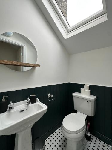 a bathroom with a white toilet and a sink at Bronte Hideaway in Haworth