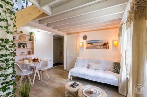 a living room with a couch and a table at Le refuge in Juaye-Mondaye