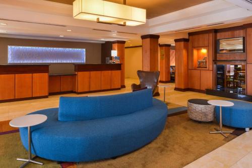 a living room with a blue couch and tables at Fairfield Inn & Suites Santa Maria in Santa Maria