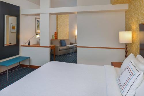 a hotel room with a bed and a living room at Fairfield Inn & Suites Santa Maria in Santa Maria