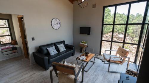 a living room with a couch and chairs and a clock at Finca del Campito in Villa Berna