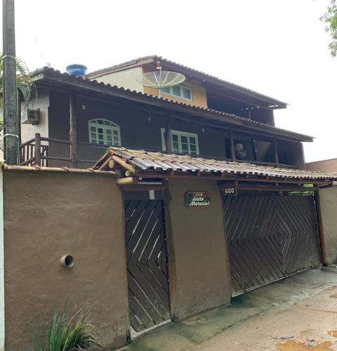 una casa con un garage con un cancello di Chalé Suites Maresias a São Sebastião