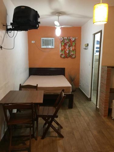 una camera con letto e tavolo e tavolo con sedie di Chalé Suites Maresias a São Sebastião