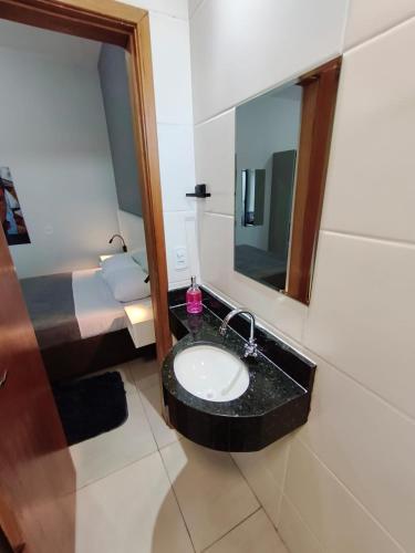 a bathroom with a black sink and a mirror at Xavi Studio in Bauru