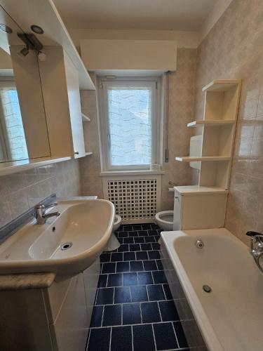 a bathroom with a sink and a tub and a toilet at Amanda Apartments in Sarche di Calavino