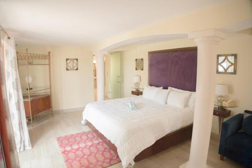 ein Schlafzimmer mit einem großen weißen Bett und einem rosa Teppich in der Unterkunft Villa Marrakesh, Cupecoy Beach - A Luxury Villa with Pool in Lowlands