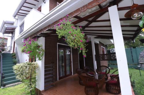 a patio of a house with chairs and flowers at Mani Villa in Wattala