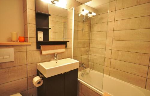 a bathroom with a sink and a bath tub at Maison à Tour Briançon in Briançon