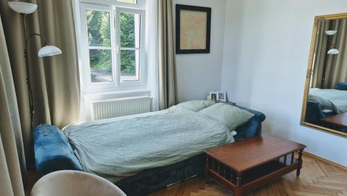 a bedroom with a bed and a table and a mirror at Villa Ohrenstein - Komfort Suite in Bad Ischl