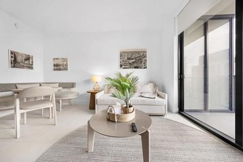 un soggiorno bianco con tavolo e divano di Upscale 1-BD Condo in DTW Miami - City Views a Miami