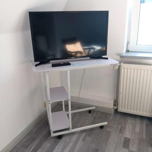 a television sitting on a white table with a chair at Monteurzimmer, Innenstadt Lage in Husum