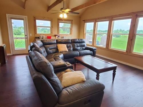 a living room with a leather couch and a table at Lodge One with Scenic View in McKinney