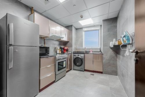 a kitchen with a refrigerator and a washing machine at Great Gatsby's Home in Dubai