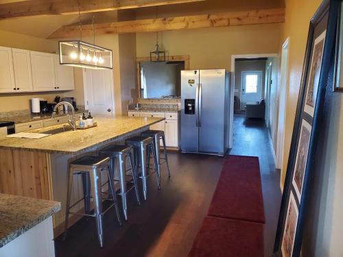 a kitchen with a refrigerator and some bar stools at Lodge One with Scenic View in McKinney