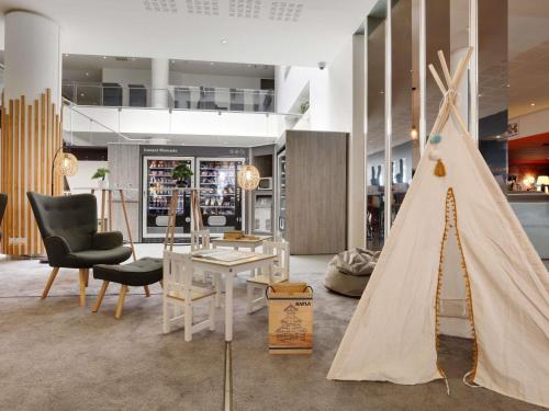 a living room with a christmas tree in the middle at Novotel Paris Est in Bagnolet