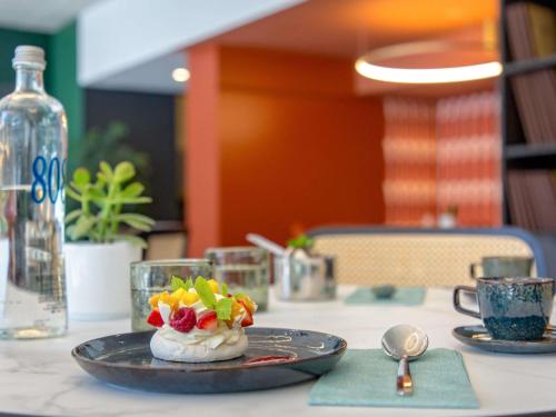 a table with a plate of food on it at Mercure Aix en Provence Beaumanoir in Aix-en-Provence