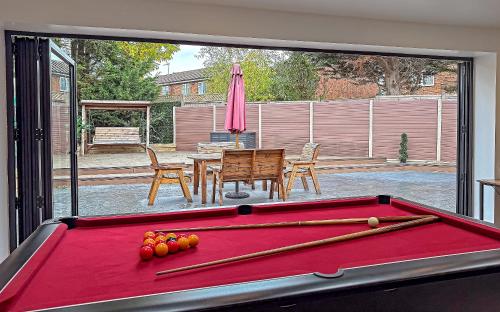 a pool table with balls and bats on top of it at Contractors Heaven-POOL TABLE-THREE BEDROOM HOUSE WITH SEPARATE ONE BEDROOM SELF CONTAINED-Close to AIRPORT in Luton