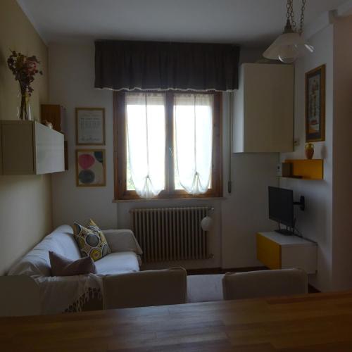 a living room with a couch and a window at Casa in collina, vista mare. in Nibbiaia