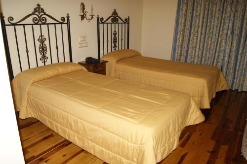 two beds in a hotel room withskirts at Hotel Riopar Spa in Riópar