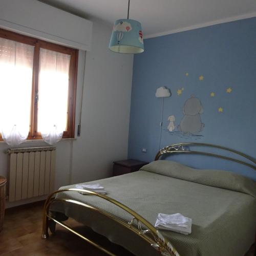 a bedroom with a bed and a blue wall at Casa in collina, vista mare. in Nibbiaia