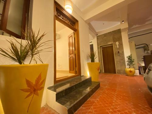 a mirror on the side of a building with two plants at La Tamara Luxury - TIE Hotels & Resorts in Pondicherry