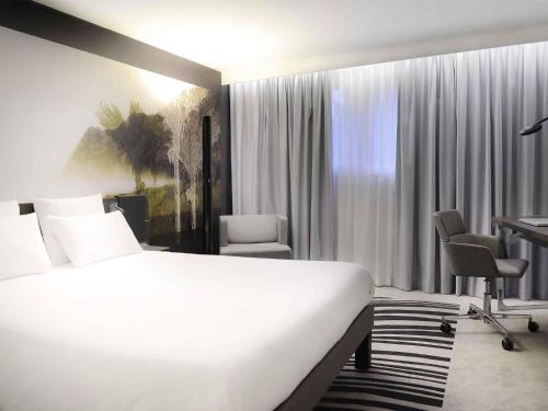 Ένα ή περισσότερα κρεβάτια σε δωμάτιο στο Novotel Caen Côte de Nacre