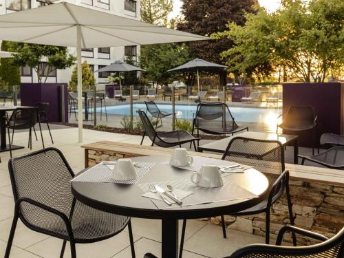 a table and chairs in front of a pool at Novotel Nancy in Nancy