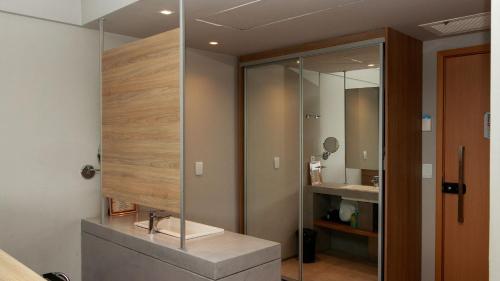 レシフェにあるPaiva Home Stay - Flat Beira-Mar em Barra de Jangada por Yoloのバスルーム(ガラス張りのシャワー、シンク付)