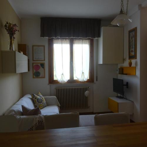 a living room with a couch and a window at Casa in collina, vista mare. in Nibbiaia
