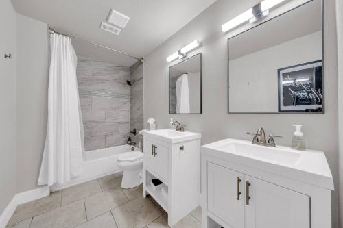 a bathroom with two sinks and a toilet and a shower at Quiet Family Friendly Getaway - Pool, 2 King Beds in San Antonio