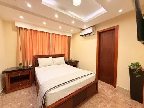 a bedroom with a large bed and a window at Suite de Lujo con Piscina en la Zona Más Exclusiva de Machala in Machala