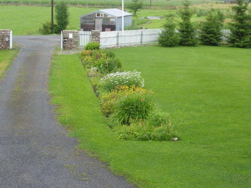 a garden with flowers on the side of a road at Villa River Rose in Jõesuu