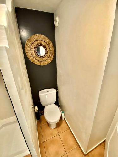 a small bathroom with a toilet and a mirror at Studio Coco Zen in Sainte-Anne