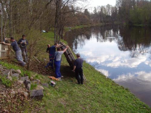 a group of people standing next to a river at Villa River Rose in Jõesuu