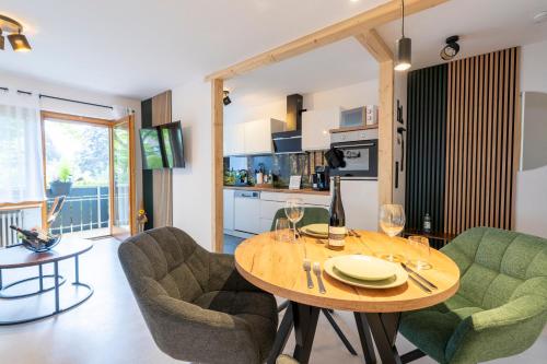 een woonkamer met een tafel en stoelen en een keuken bij WälderNestchen - zentral - Natur pur - Tiefgarage - Balkon - modernes 2 Zimmer Appartement in Lenzkirch