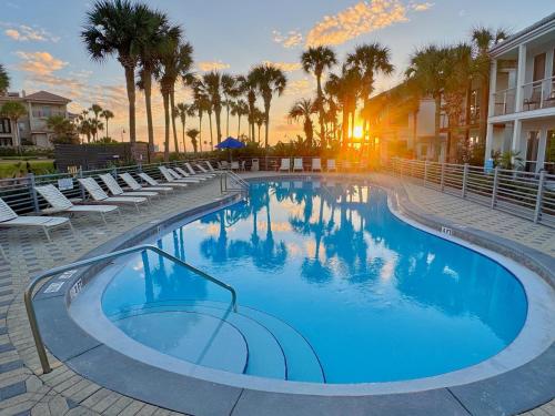 une grande piscine avec chaises et palmiers dans l'établissement Margarita Villa B- Heated Pool, Beach, Waterfront, à Destin