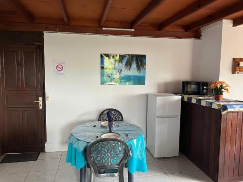 a small kitchen with a table and a refrigerator at Habitation Quenette in Le Gosier