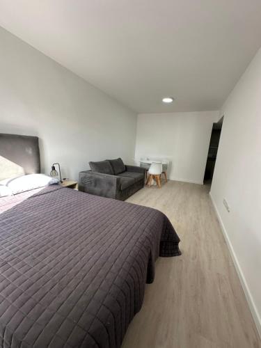 ein Schlafzimmer mit einem Bett und einer Couch in der Unterkunft MOVISTAR ARENA PREMIUM THAMES 56 8 piso 812 Cocheras y Seguridad in Buenos Aires