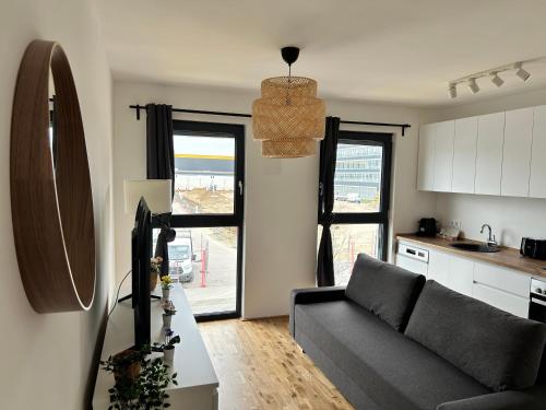 a living room with a couch and a kitchen at Modern Apartment with Terrace & Free Parking - Nearby Metro in Vienna