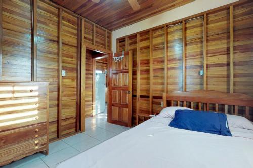 a bedroom with wood paneled walls and a bed at Loft at Roughrider Inn -Gold Standard Certified in Caye Caulker