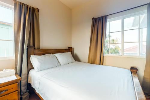 a bedroom with a white bed and two windows at Grama Tasha at Isebei Guest House -Gold Standard Certified in Hopkins