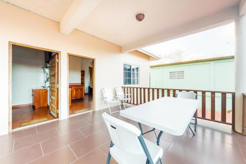 a dining room with a table and chairs on a balcony at Grama Tasha at Isebei Guest House -Gold Standard Certified in Hopkins