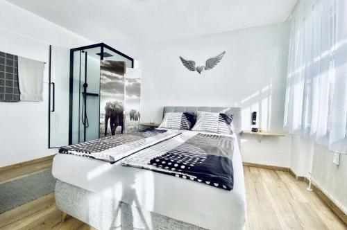 a white bedroom with a large bed in it at BacherlHouse - Apt Steinbach in Schörfling
