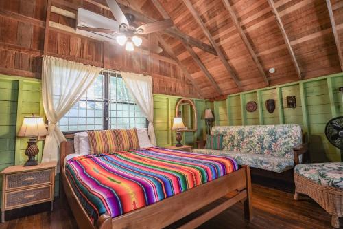 a bedroom with a bed and a ceiling fan at Ara Macao Beach House at Ocean’s Edge -Gold Standard Certified in Maya Beach