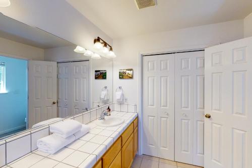 Un baño con lavabo y un espejo grande. en Moler Lake House, en Bass Lake